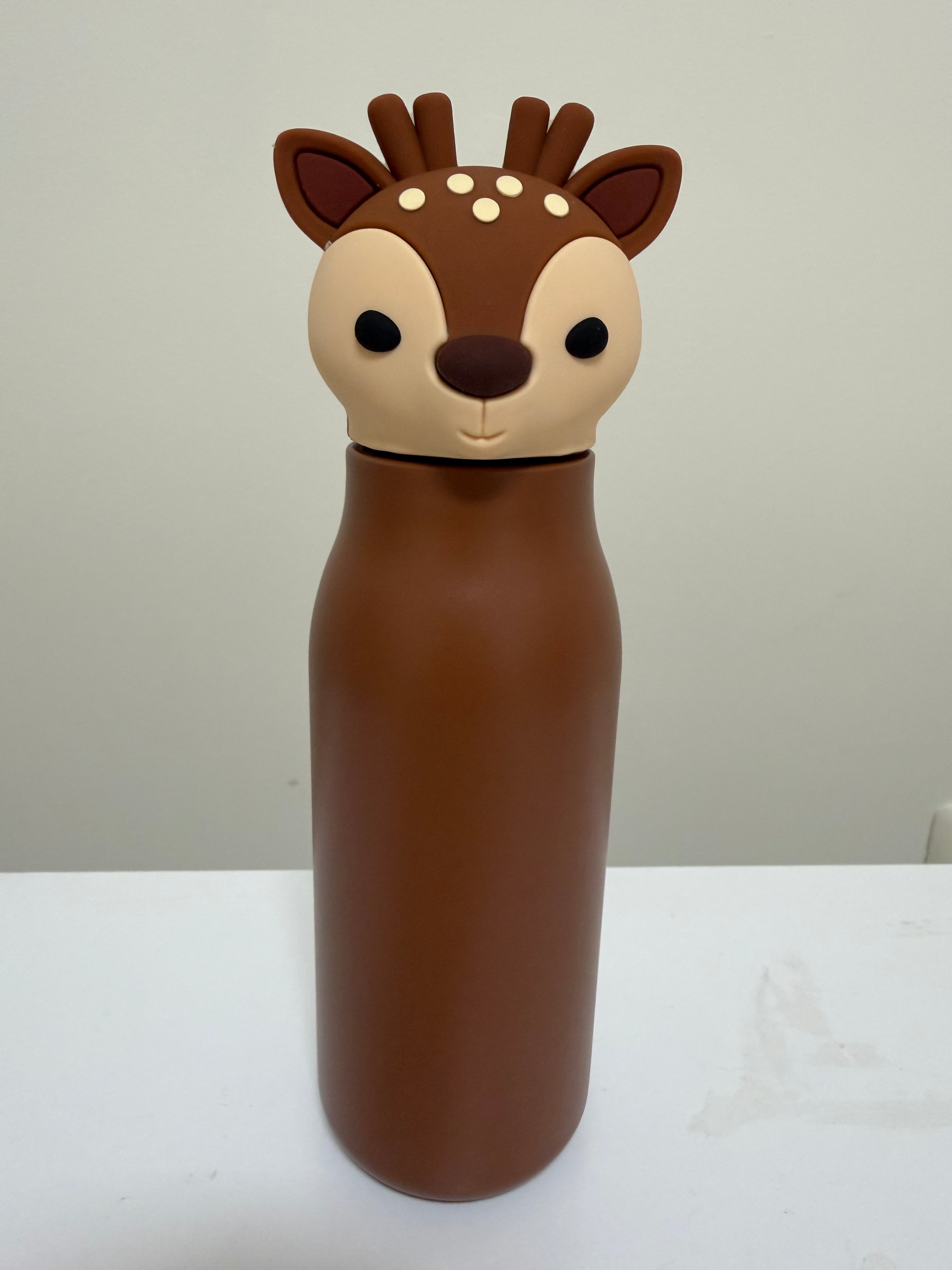 A brown insulated bottle with a cute deer head lid, featuring a cream-colored snout and ears with small white spots, set against a plain light gray background.
